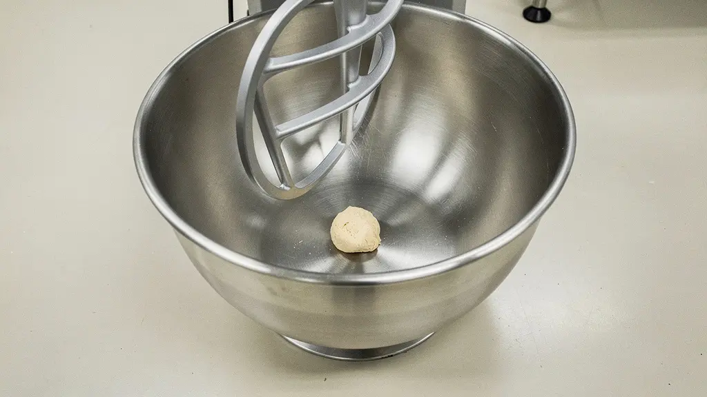 Petite quantité de pâte au fond d’une grande cuve de pétrin à spirale, illustrant le manque d’inertie et de tension dans le réseau glutineux.